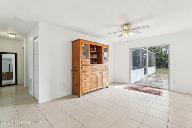 spare room featuring ceiling fan, visible vents, and light tile patterned flooring