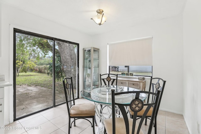 dining space featuring light tile patterned flooring and baseboards