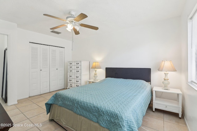 bedroom featuring a ceiling fan, a closet, visible vents, and light tile patterned flooring