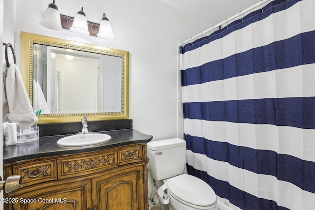 bathroom featuring toilet, a shower with shower curtain, and vanity