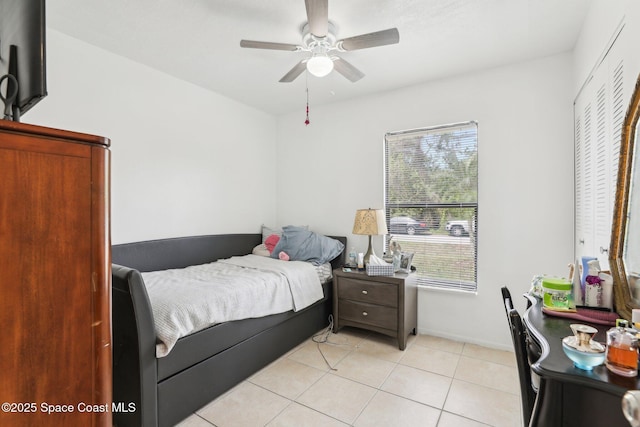 bedroom with light tile patterned floors, ceiling fan, and baseboards