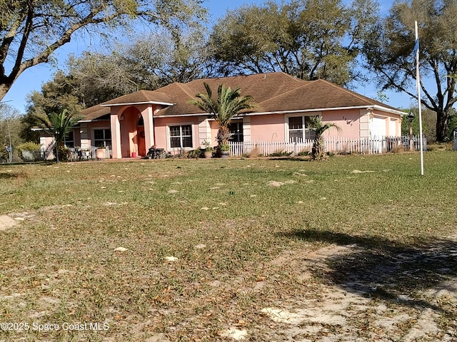 view of front facade featuring a garage, fence, a front lawn, and stucco siding