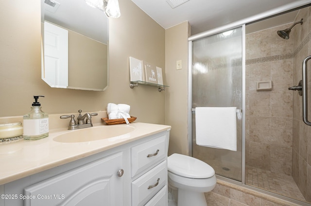 bathroom with visible vents, toilet, a stall shower, and vanity