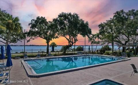 community pool with a patio area and fence