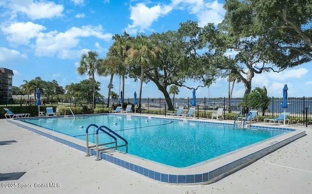 pool with a patio and fence