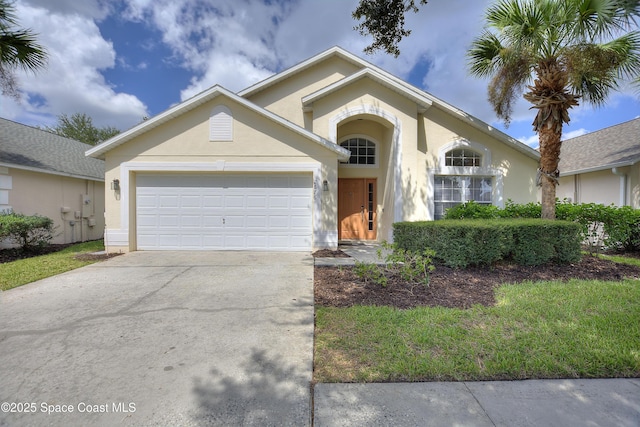 view of front facade featuring a garage, driveway, and stucco siding