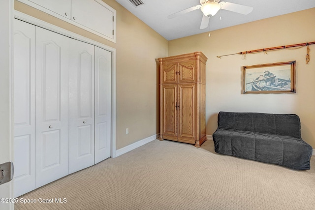 sitting room featuring baseboards, light colored carpet, and a ceiling fan