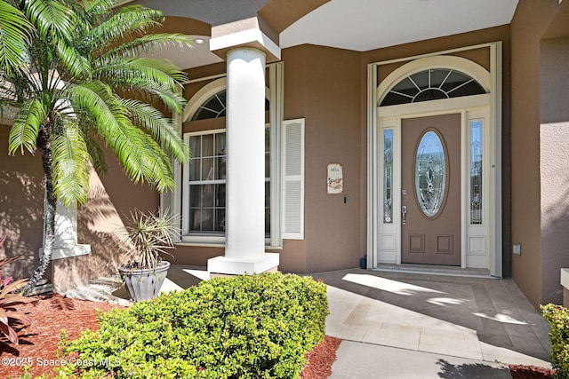 entrance to property with stucco siding and a porch