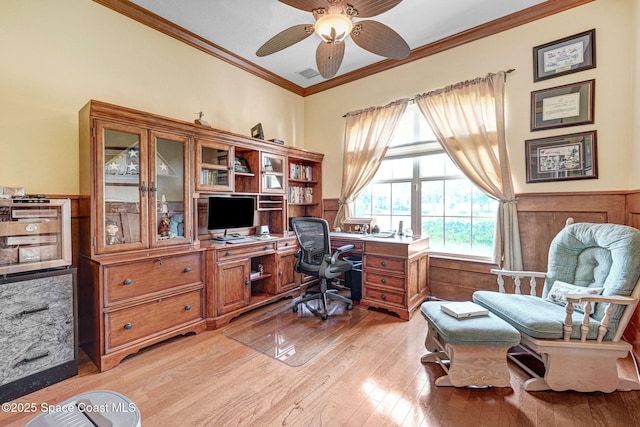 office area with visible vents, crown molding, ceiling fan, light wood-style flooring, and wainscoting