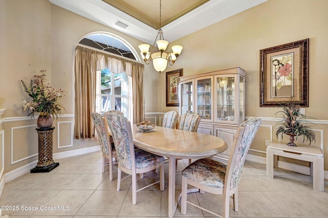 dining room featuring light tile patterned floors, visible vents, an inviting chandelier, and a decorative wall