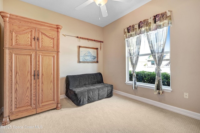 sitting room with baseboards, carpet floors, and ceiling fan