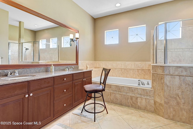 full bathroom with double vanity, a garden tub, a tile shower, and a sink