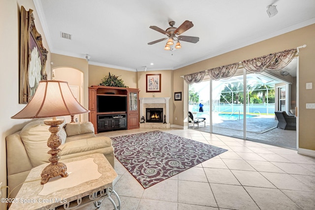 living room with visible vents, baseboards, ceiling fan, ornamental molding, and light tile patterned floors