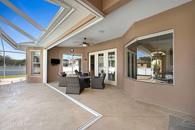 view of patio / terrace with a ceiling fan, a lanai, and french doors