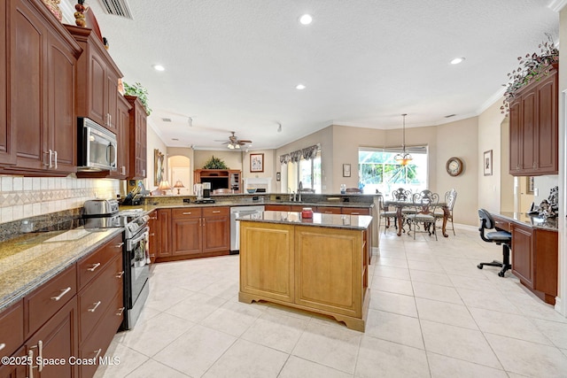 kitchen with visible vents, a ceiling fan, appliances with stainless steel finishes, a peninsula, and light tile patterned floors