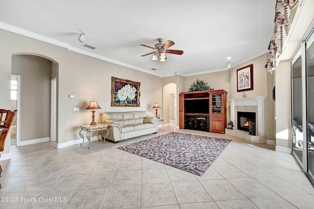 living area featuring visible vents, arched walkways, ceiling fan, and crown molding