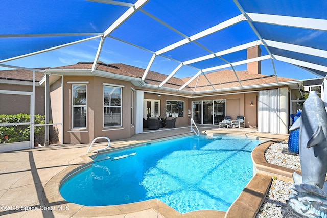 outdoor pool with glass enclosure and a patio area