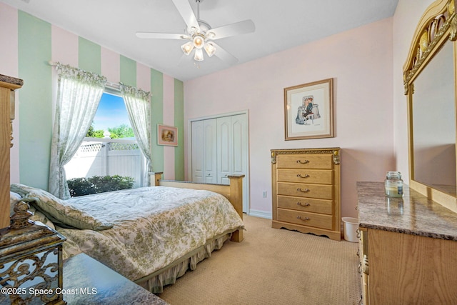 bedroom featuring a ceiling fan, light colored carpet, and a closet