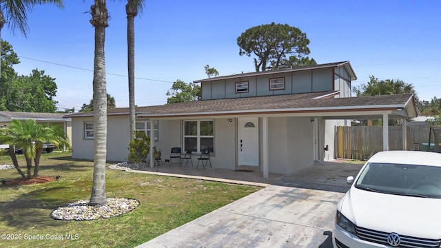 2013 Rollins Dr, Cocoa, FL 32922 - traditional home with covered porch, an attached carport, roof with shingles, stucco siding, and concrete driveway