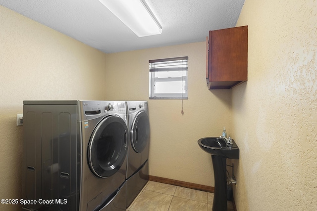 2013 Rollins Dr, Cocoa, FL 32922 - clothes washing area featuring cabinet space, washer and dryer, light tile patterned flooring, and baseboards