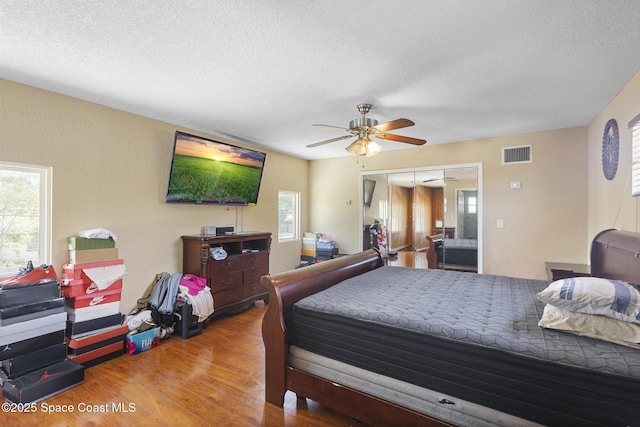 2013 Rollins Dr, Cocoa, FL 32922 - bedroom with wood finished floors, multiple windows, a textured ceiling, a closet, and a ceiling fan