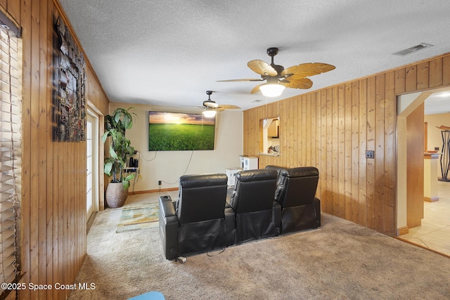 2013 Rollins Dr, Cocoa, FL 32922 - cinema room with wooden walls, carpet floors, a ceiling fan, a textured ceiling, and arched walkways