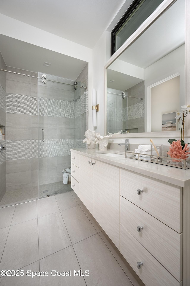 full bathroom featuring a stall shower, tile patterned flooring, and vanity