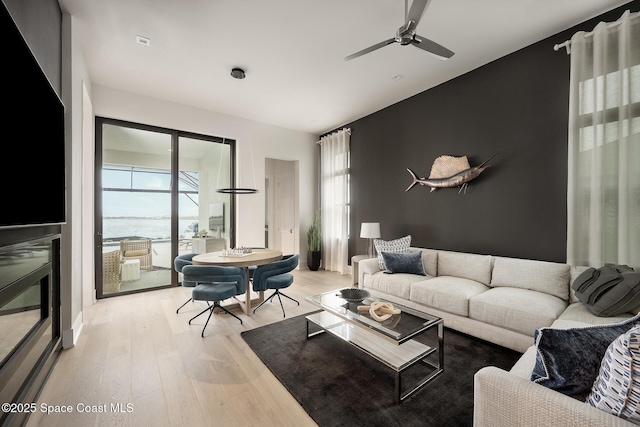 living room featuring a healthy amount of sunlight, light wood-style floors, and ceiling fan