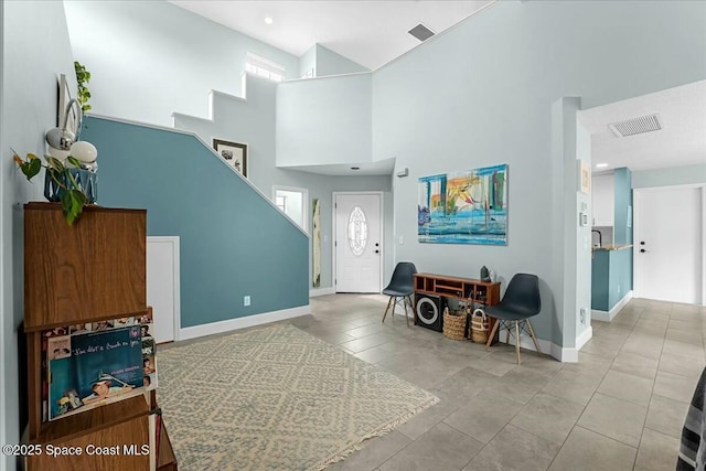 tiled entryway featuring plenty of natural light, visible vents, and baseboards