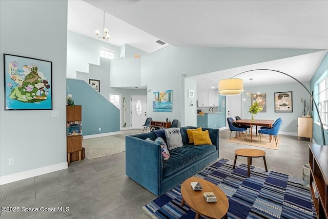 living area featuring high vaulted ceiling, visible vents, a chandelier, and baseboards