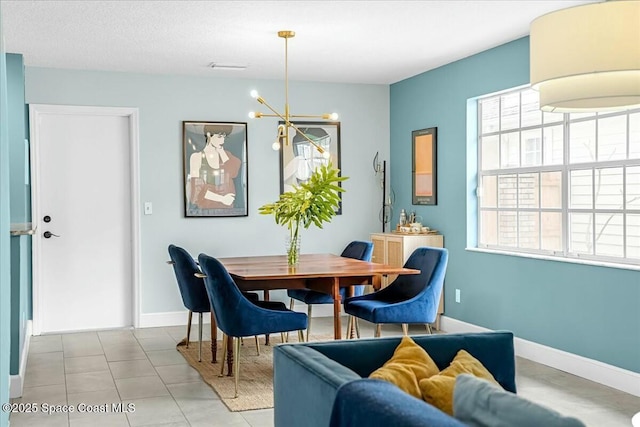 dining space featuring light tile patterned floors, an inviting chandelier, and baseboards