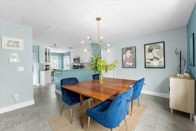 dining room with a chandelier and baseboards