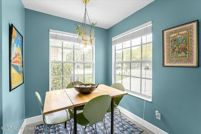 dining area with a notable chandelier and baseboards