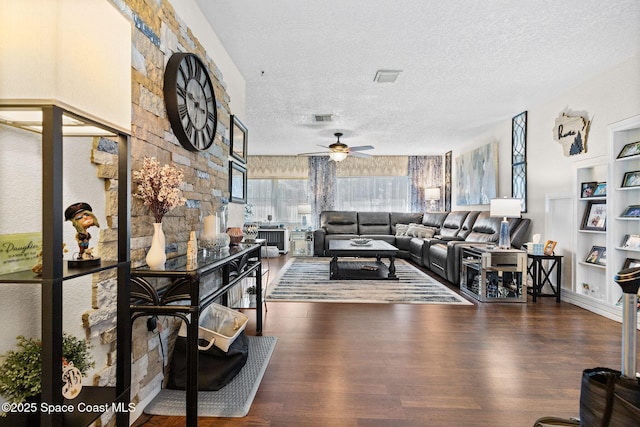 living area with visible vents, ceiling fan, a textured ceiling, and wood finished floors