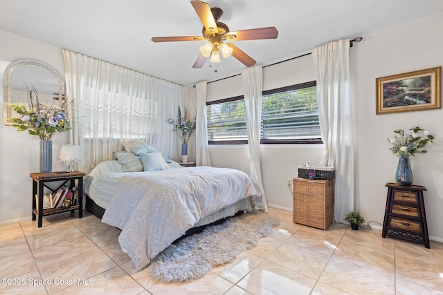 bedroom with ceiling fan, baseboards, and light tile patterned floors