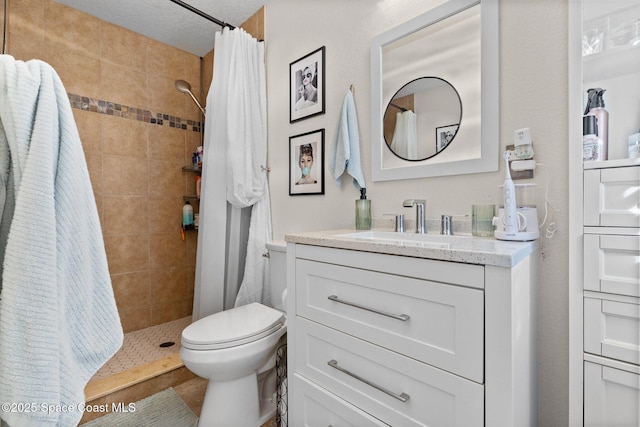 bathroom with tiled shower, vanity, and toilet