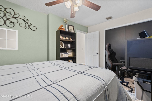 bedroom with ceiling fan, a closet, visible vents, and a textured ceiling