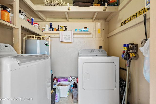 clothes washing area with washing machine and dryer, laundry area, and water heater