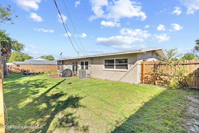 rear view of house with a patio area, a fenced backyard, a lawn, and stucco siding