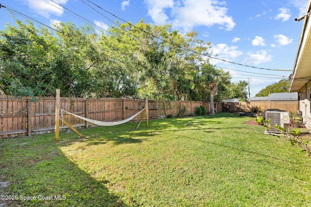 view of yard featuring a fenced backyard and central AC