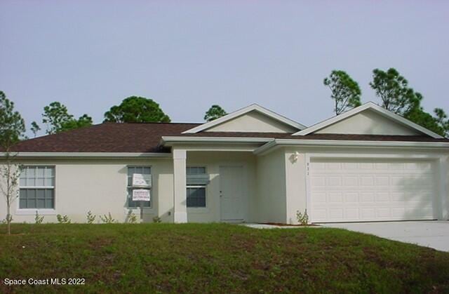 single story home featuring a front lawn, concrete driveway, an attached garage, and stucco siding