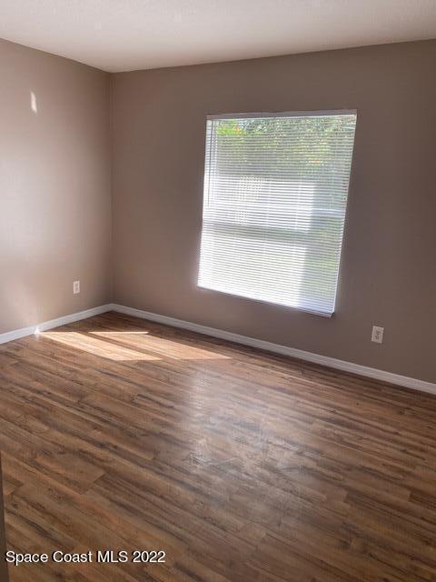 empty room with baseboards and wood finished floors