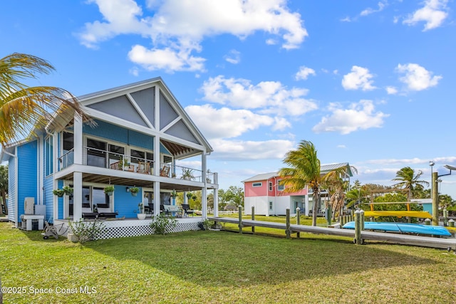 rear view of house featuring a yard and a balcony