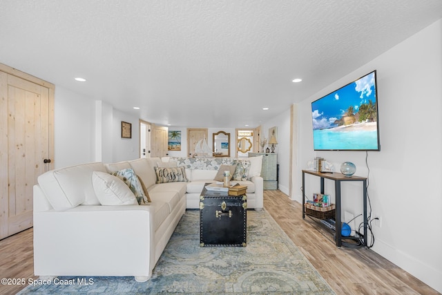 living room with a textured ceiling, baseboards, wood finished floors, and recessed lighting