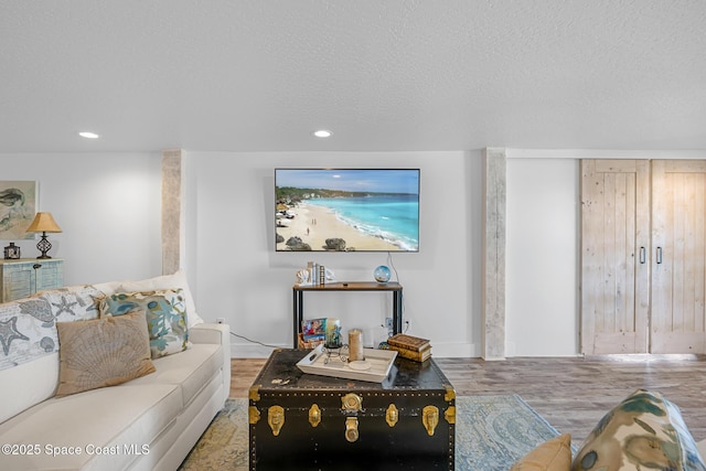 living room featuring a textured ceiling, wood finished floors, and recessed lighting