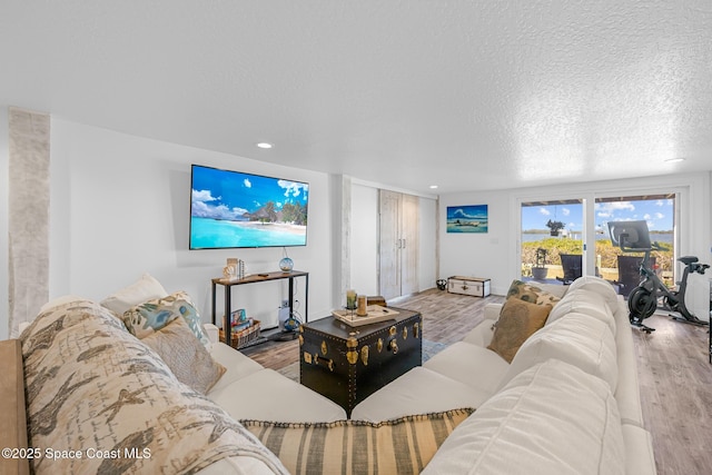 living area featuring recessed lighting, a textured ceiling, and wood finished floors