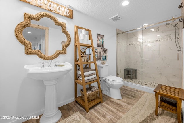 full bath featuring visible vents, a marble finish shower, wood finished floors, and toilet