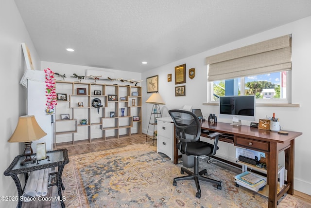 office space with a textured ceiling, baseboards, wood finished floors, and recessed lighting