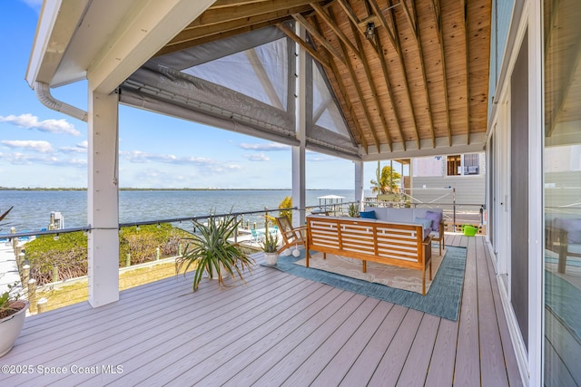 wooden deck with a water view and an outdoor living space