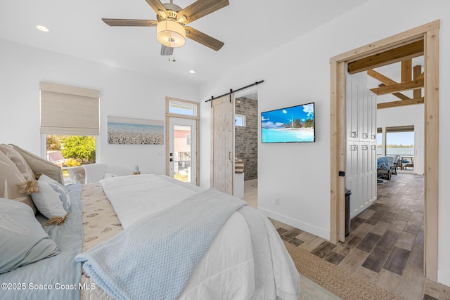 bedroom with a barn door, recessed lighting, wood finished floors, a ceiling fan, and baseboards